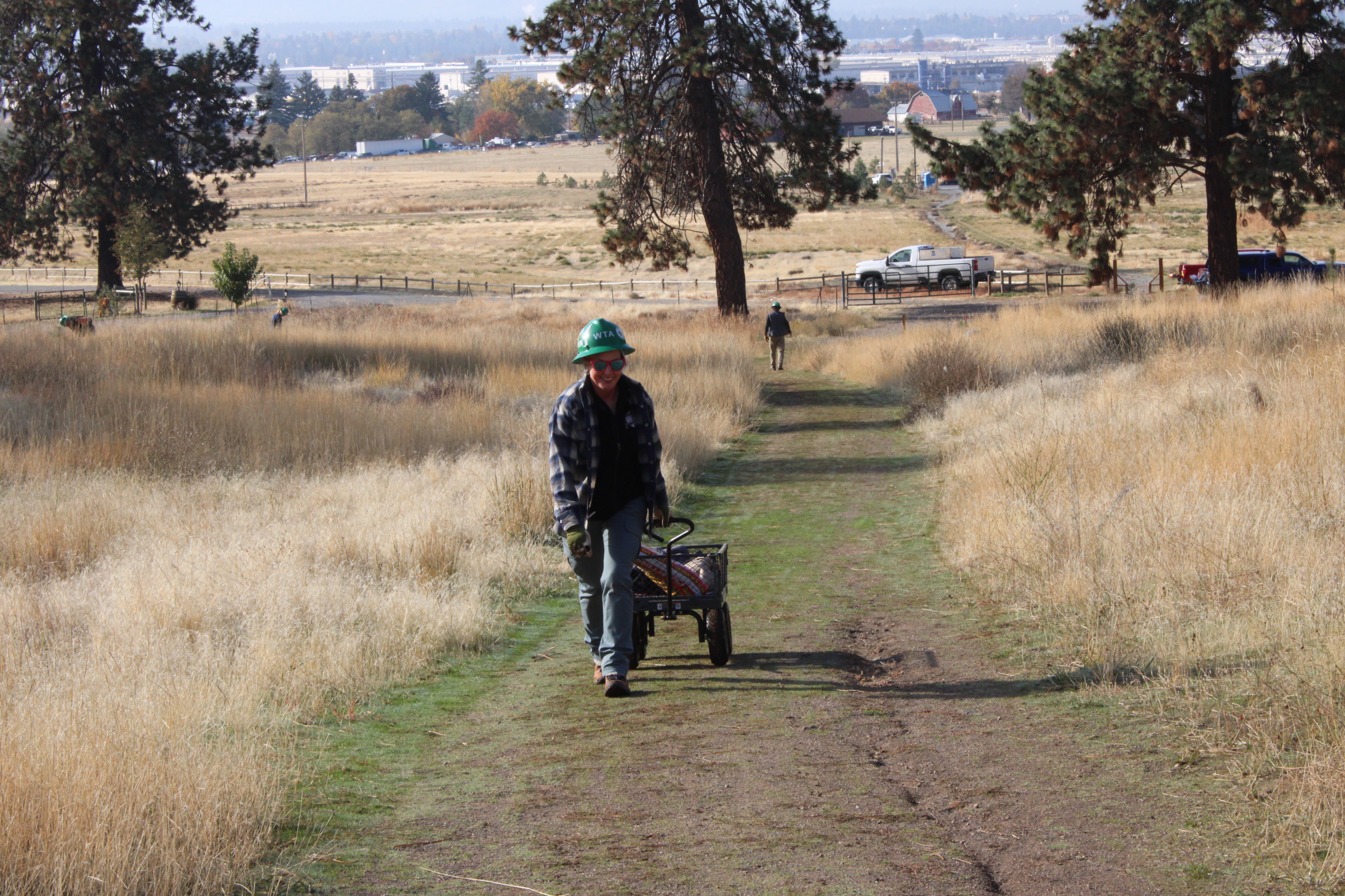 Volunteer hauling bags of planting soil uphill